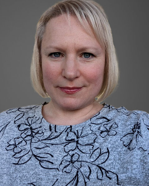 michelle-new Michelle, a woman with blonde hair, wearing a grey floral top, smiling for a new selfie.